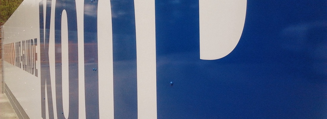 Nahaufnahme einer blauen Außenbeschriftung an einer Gebäudefassade in Hamburg Bergedorf