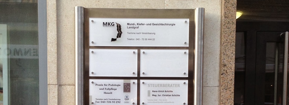 Schilder in einem Hamburger Bürogebäude, die wichtige Firmeninformationen vermitteln.