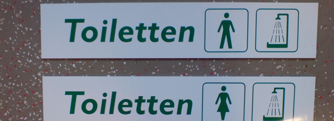 Schilder für Toiletten in einem öffentlichen Gebäude in Hamburg, gut sichtbar und einfach zu erkennen.
